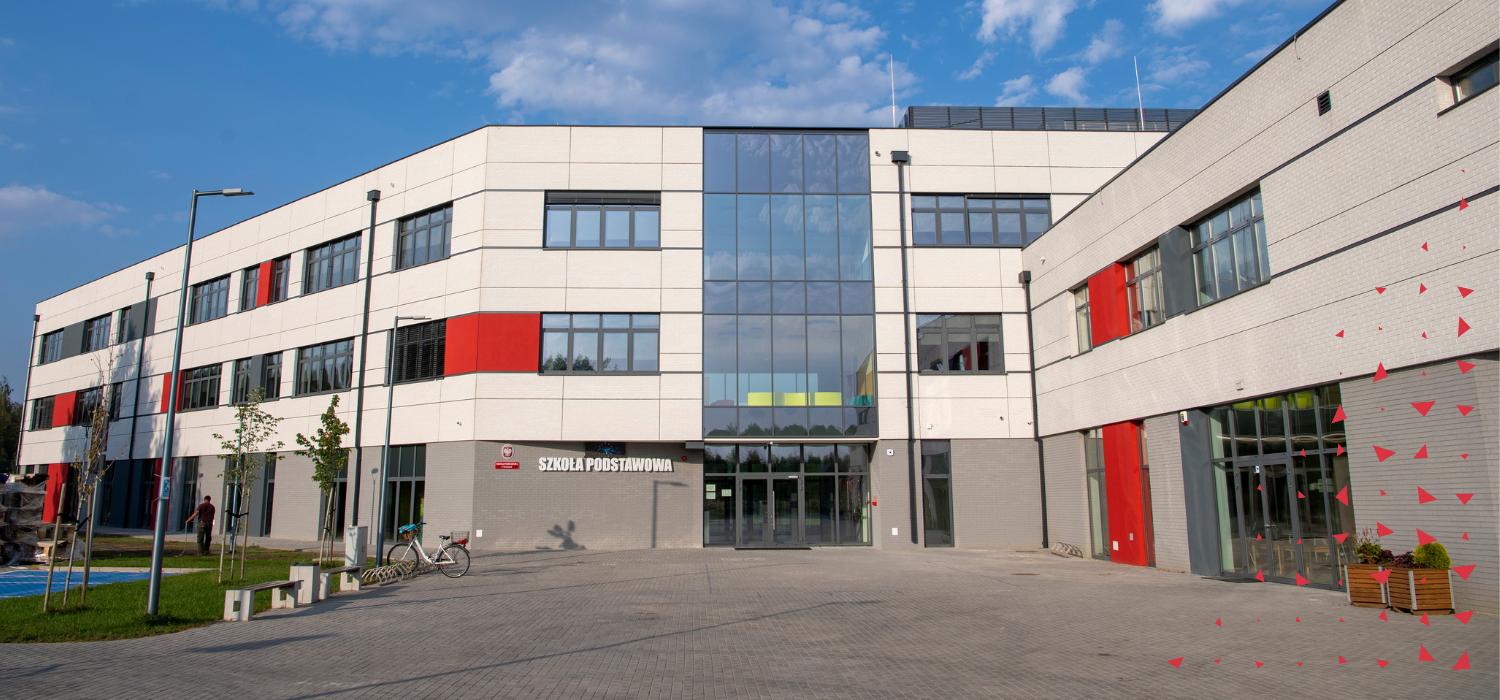 Obraz przedstawiający dwupiętrowy budynek z napisem szkoła podstawowa obok wejścia